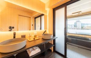 een badkamer met 2 wastafels en een groot raam bij TABITABI STAY KAWAMA in Kyoto +18 foto's