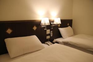 a hotel room with two beds and a telephone at Melody Hotel in Taitung City