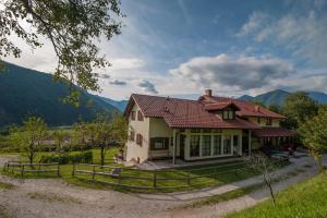 a house in the mountains with a fence at Tourist Farm Pri Kafolu in Tolmin