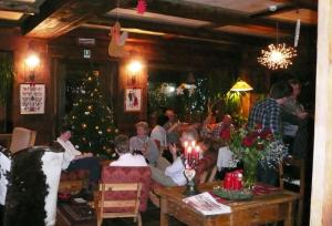Un grupo de personas sentadas en una habitación con un árbol de Navidad en Hotel Mignon, en Breuil-Cervinia