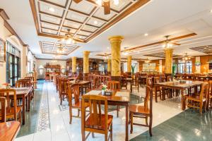 un restaurant vide avec des tables et des chaises en bois dans l'établissement Tony Resort, à Patong Beach