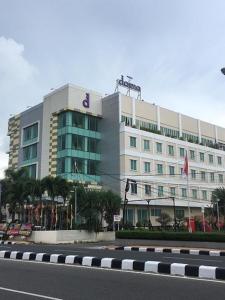 ein großes weißes Gebäude mit einem Schild darüber in der Unterkunft Daima Hotel Padang in Padang
