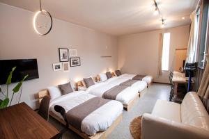 a hotel room with two beds and a couch at UCHI Living Stay TOYOHIRA in Sapporo
