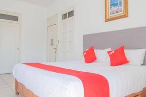 Un dormitorio con una gran cama blanca con almohadas rojas. en Hotel Imperial, en Aguascalientes