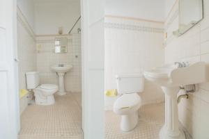 baño con 2 aseos y lavamanos en Hotel Imperial, en Aguascalientes