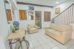 ein Wohnzimmer mit einem Sofa, einem Tisch und Stühlen in der Unterkunft Hotel Imperial in Aguascalientes