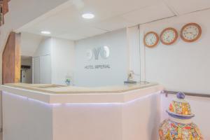 a room with clocks on the wall and a counter at Hotel Imperial in Aguascalientes