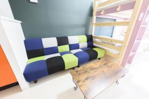 ein Sofa in einem Zimmer neben einem Etagenbett in der Unterkunft Cocostay KO Residence Sennichimae6Fココステイ ケーオーレジデンス センニチマエ6F in Okayama