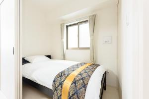 a small bedroom with a bed and a window at COCOSTAY月光千日前6F - Cocostay Gekkou Sennichimae6F in Okayama