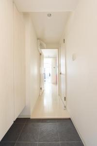 an empty hallway with white walls and a tile floor at Cocostay KO Residence Sennichimae3Fココステイ ケーオーレジデンス センニチマエ3F in Okayama
