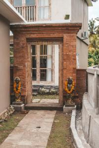 a brick entrance to a house with orange garland at Alamdhari Resort and Spa in Sidemen