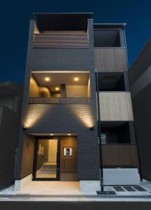 uma casa preta com uma porta da frente na noite em 雪時雨-大正 em Osaka