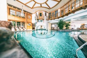a swimming pool in a hotel with a large building at Wellnesshotel Warther Hof in Warth am Arlberg