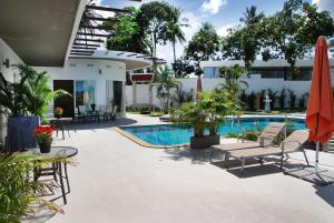 a patio with chairs and a swimming pool at The Inspiration Residence in Rawai Beach