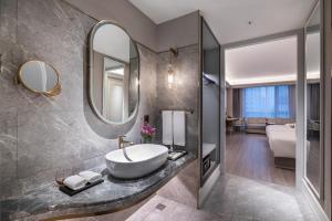 上海上海徐汇日月光美居酒店的浴室里有洗手池和镜子