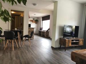 a living room with a television and a table and chairs at Castrum Bucowe in Buckow