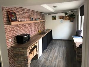 a kitchen with a brick wall and a counter with a microwave at Castrum Bucowe in Buckow