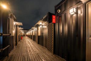 a long hallway with a wooden walkway at night at HOTEL R9 The Yard Utsunomiya chuo in Utsunomiya