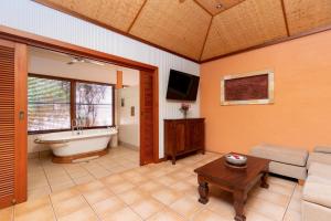a living room with a tub and a couch and a table at Bali Hai Resort & Spa in Broome