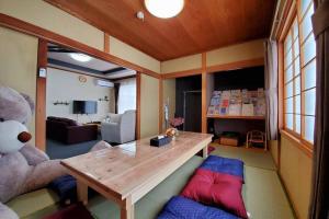 a living room with a teddy bear and a wooden table at 旭川ファミリーハウスみんみん in Asahikawa