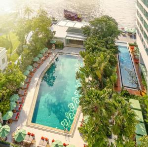 
a swimming pool with a balcony overlooking a city at Mandarin Oriental Bangkok - SHA Extra Plus in Bangkok
