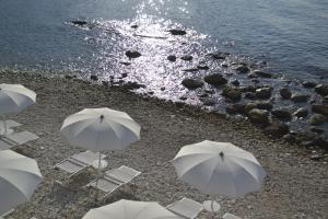 a group of chairs and umbrellas on a beach at La Casa E Il Mare, Private Bay Hotel in Mattinata