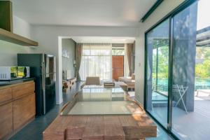 a living room with a glass table in the middle at SEAnery Beach Resort in Bang Saphan
