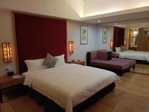 una camera d'albergo con un letto grande e una sedia di Dongguan Well Garden Hotel a Dongguan