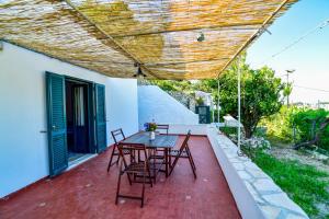 eine Terrasse mit einem Tisch und Stühlen sowie einem Holzdach in der Unterkunft SoleMarePonza casa Antonietta in Ponza