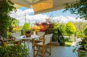 a patio with a table and chairs and a fence at Laconian Collection : Harision Residence : in Sparti