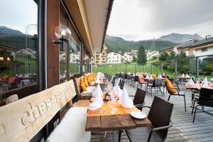 restauracja ze stołami i krzesłami na balkonie w obiekcie Hotel Chesa Surlej w mieście Silvaplana
