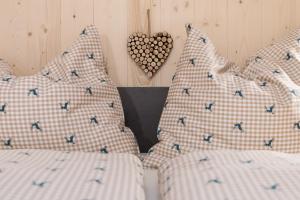 a bedroom with two beds with pillows and a heart at Chalet Sunnseitn - auf der Turracher Höhe in Turracher Hohe
