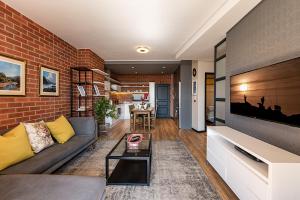 a living room with a couch and a brick wall at The Rosebank collection in Johannesburg