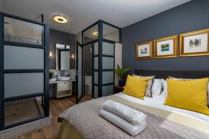 a bedroom with a large bed with yellow pillows at The Rosebank collection in Johannesburg