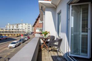 d'un balcon avec une table et une vue sur la rue. dans l'établissement Seapoint - Sea view, à Zandvoort