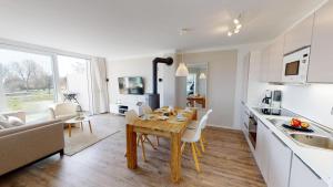 a kitchen and living room with a wooden table and chairs at Beach'n'Sea Wohnung 6 in Grömitz