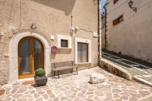 um banco em frente a um edifício com uma porta em LOFT DI DESIGN ESCLUSIVO em Rocca di Mezzo