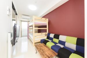 a living room with a couch and a tv at COCOSTAY月光千日前6F - Cocostay Gekkou Sennichimae6F in Okayama