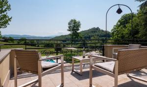 patio ze stołem i krzesłami na balkonie w obiekcie Relais Il Furioso w mieście Monte Castello di Vibio