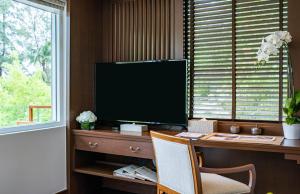 a living room with a tv and a window at Anantara Layan Phuket Resort - SHA Extra Plus in Layan Beach