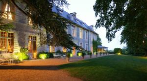 un grande edificio con un prato di fronte di Château De Noirieux a Briollay