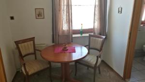 a dining room table with chairs and a window at Pension Hoffmann in Wuppertal +8 photos