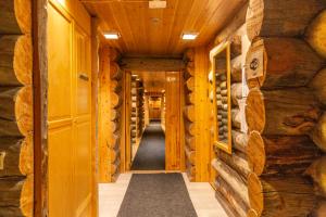 a hallway in a log cabin with wooden walls at Kuukkeli Log Houses Teerenpesä in Saariselka
