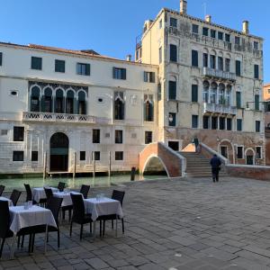 a group of tables and chairs in front of a building at Home Lovers Apartment in Venice