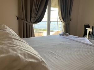um quarto com uma cama e vista para o oceano em Kotarja Apartments em Dhërmi