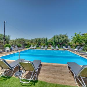 una gran piscina con sillas y una terraza con en Valentina Apartments, en Gouves