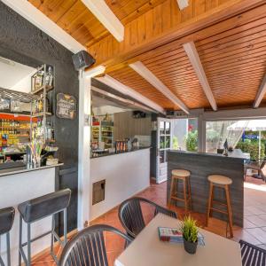 un restaurante con techos de madera, mesas y sillas en Valentina Apartments, en Gouves