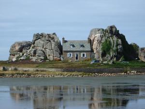 an old house on an island in the water at Best Western Les Bains Hotel et SPA in Perros-Guirec