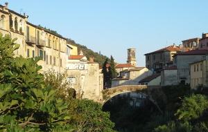 un ponte sul fiume in una città con edifici di Appartamento Stefano a Dolcedo