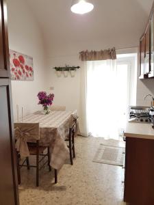 una cucina con tavolo e vaso di fiori di Appartamento Stefano a Dolcedo
